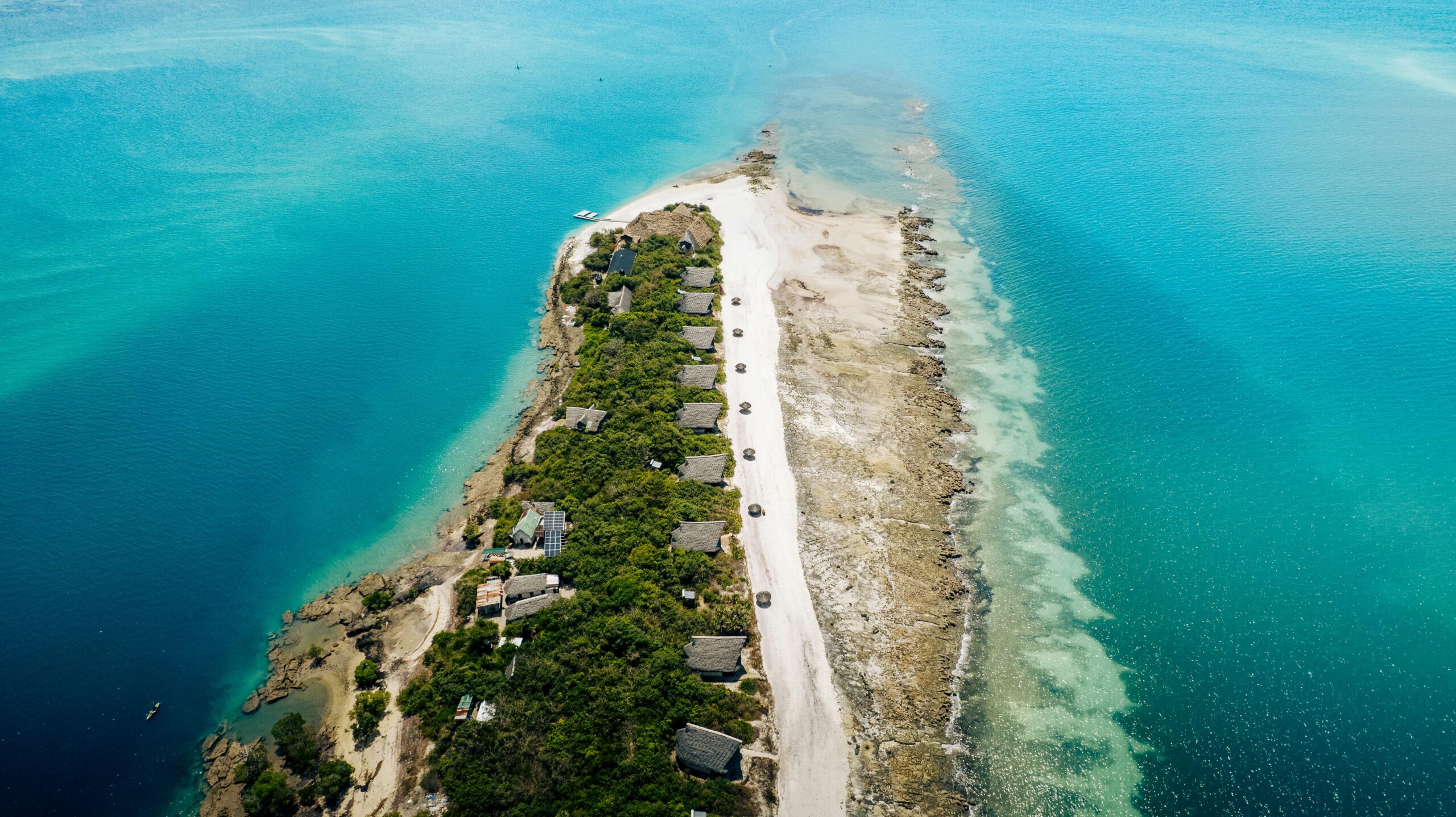 Stunning aerial photo of a coastal island surrounded by clear turquoise waters.