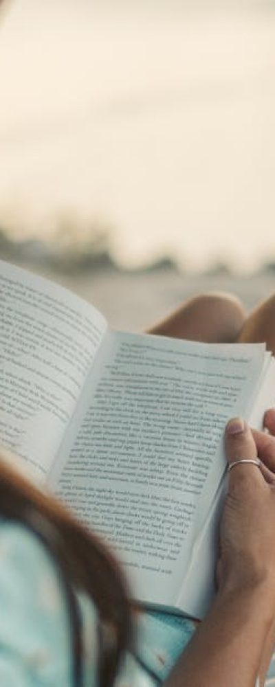 Woman reading on a beach in Zanzibar while enjoying the serene coastal view.